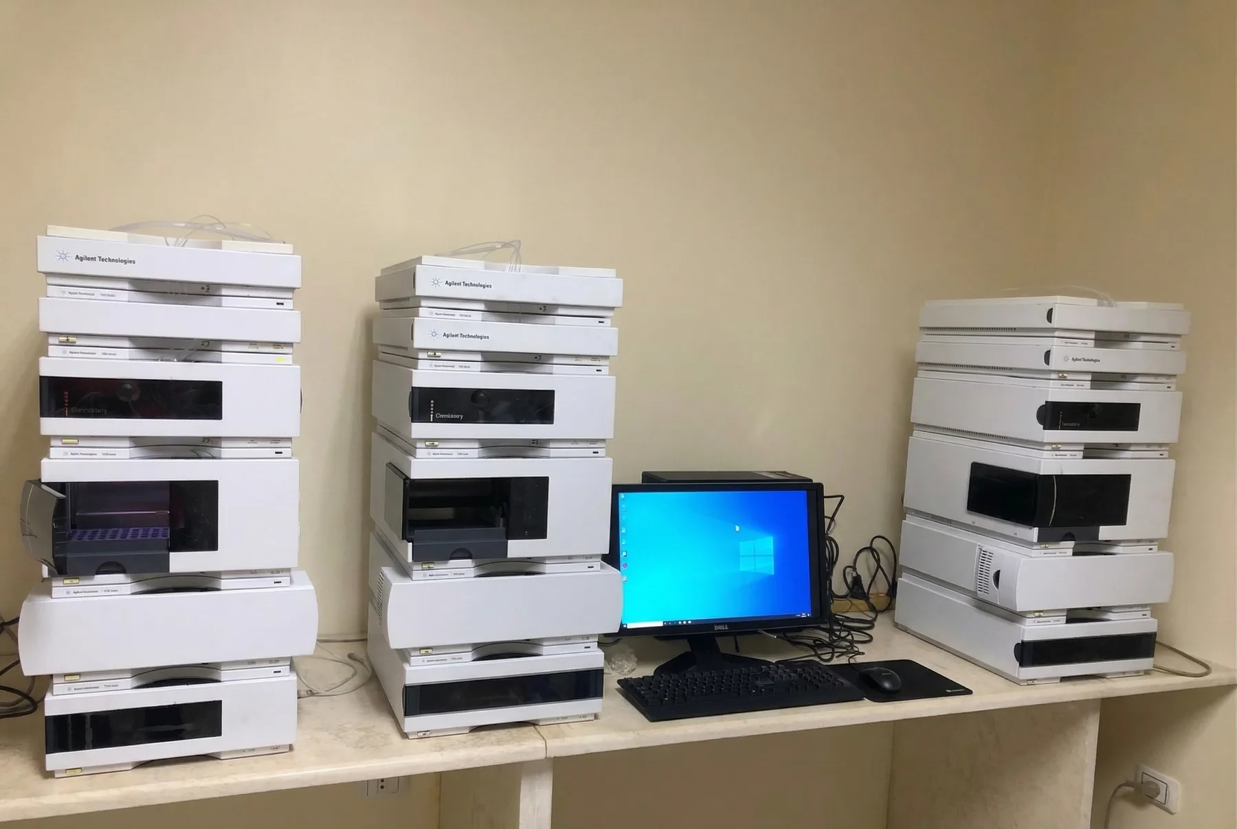 Three refurbished Agilent 1200 HPLC systems set up side by side with a control workstation